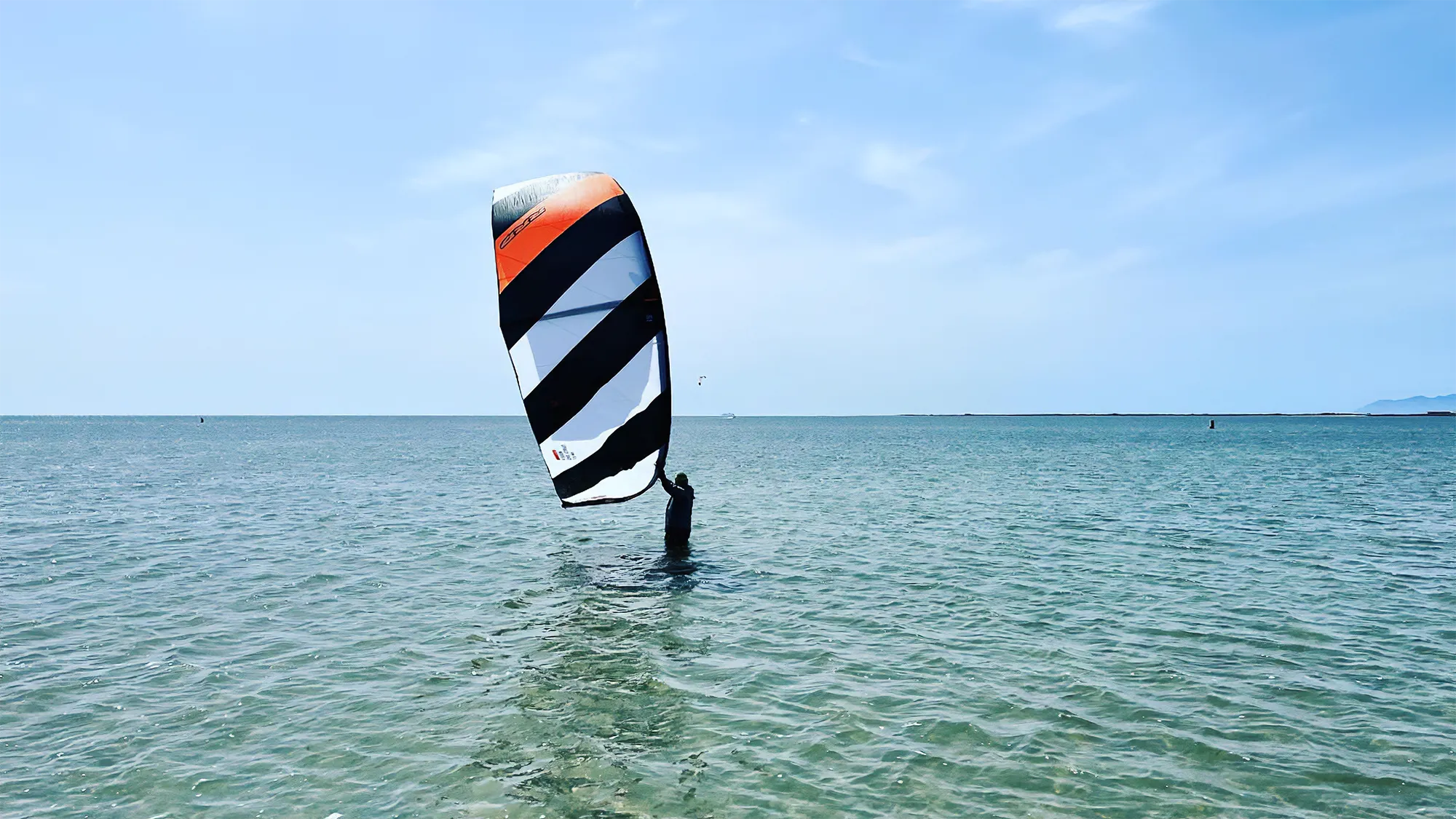 a kitesurfer holds his kite